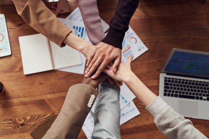 Equipe unindo as mãos em colaboração